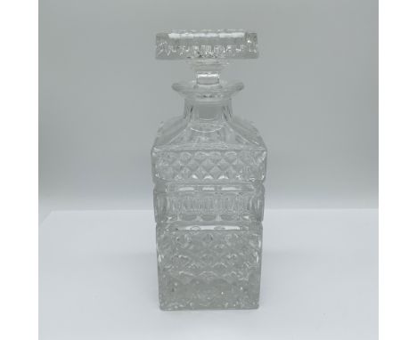 Elegant cut glass whiskey decanter featuring a striking geometric pattern with diamond and hobnail detailing. The squared bod
