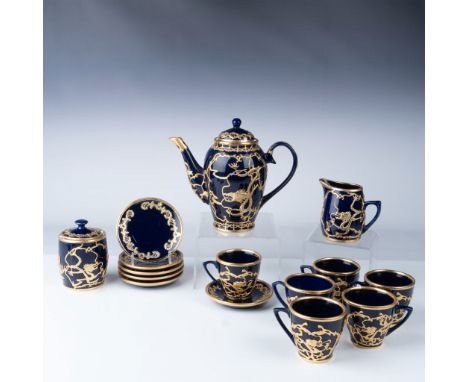 This 15-piece tea set features an intricate dragon motif outlined in gilded accents over a deep cobalt blue glaze. The set in