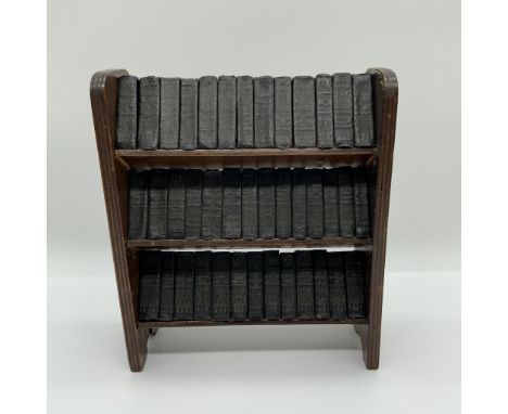 A finely crafted miniature book collection featuring the works of William Shakespeare, housed in a vintage wooden bookshelf. 