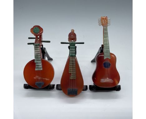 This exquisite set comprises six miniature Chinese musical instruments, each meticulously carved from semi-precious stones su