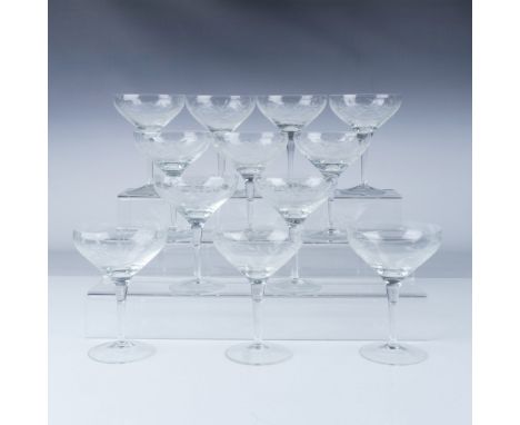 This set includes twelve beautiful crystal stemware glasses, each featuring delicate floral engravings around the bowl. The d