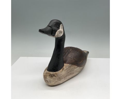 This hand-carved wooden goose decoy is a fine example of traditional craftsmanship. The piece features realistic hand-painted
