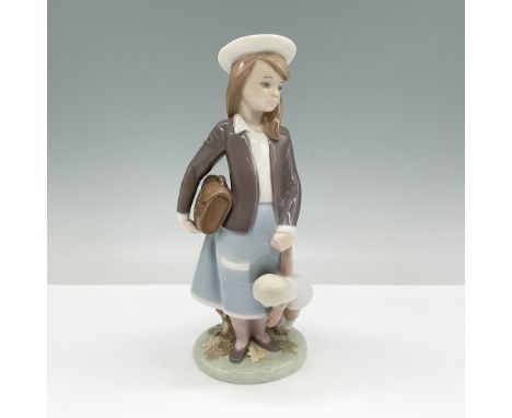 A charming Lladro porcelain figurine titled Autumn, model number 01005218. This delightful piece features a young girl dresse