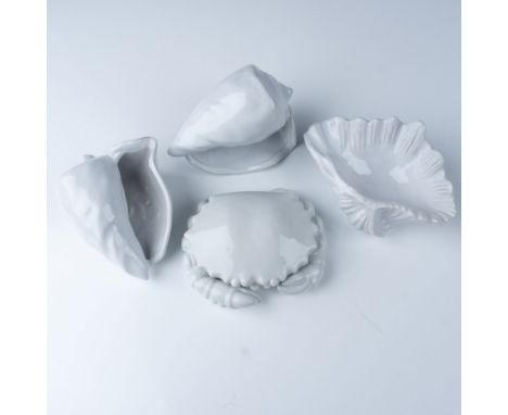 This elegant set of four ceramic pieces evokes the beauty of coastal design with its smooth white glaze and shell-inspired sh