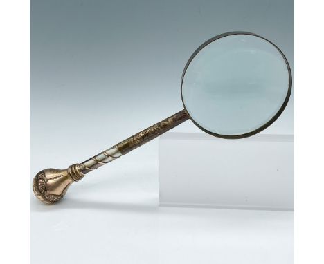 Antique magnifying glass featuring an ornately detailed handle with brass embellishments and mother-of-pearl inlays in a spir