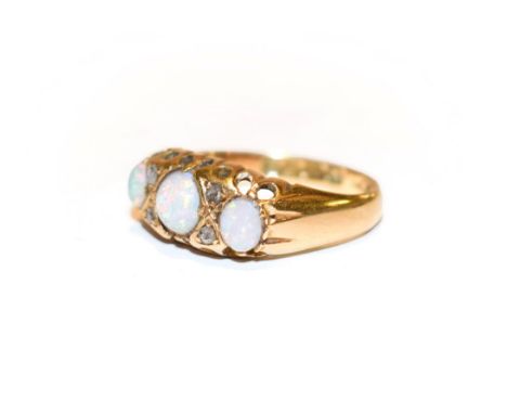 An 18 carat gold opal three stone ring with rose cut diamond accents, finger size M.  Gross weight 2.9 grams. 