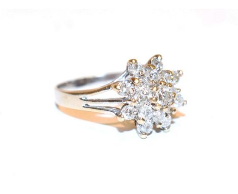 A diamond cluster ring, the raised central round brilliant cut diamond within a double border of smaller round brilliant cut 
