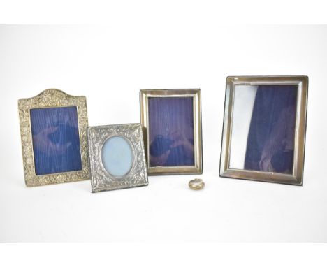 Four late 20th century silver photograph frames, two with embossed decoration, the largest 21cm x 16cm, and a George V silver