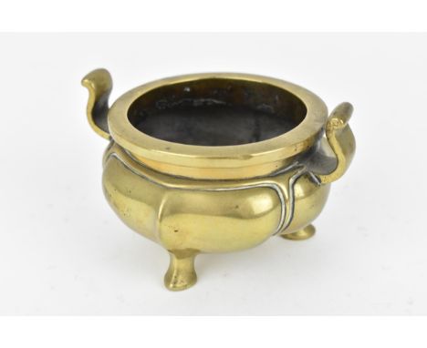 A Chinese bronze tripod censer, with lotus shaped base and curved twin handles, the underside with kaishu script Xuande mark 