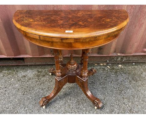 A late Victorian figured walnut and marquetry demi-lune card table, over turned columns, on splayed legs and castor, 72cm hig