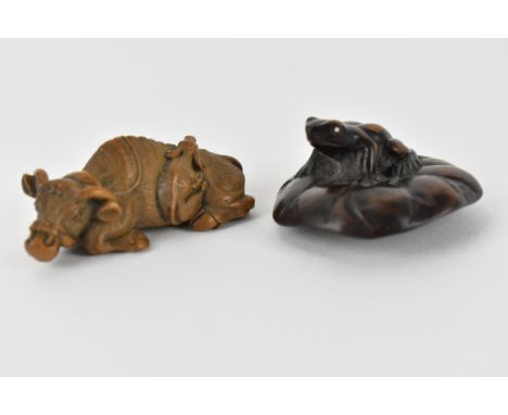 Two early 20th century Japanese wood netsuke of a recumbent water buffalo and its offspring, signed to base, 6cm w and a frog
