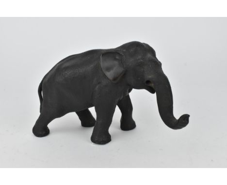 A Japanese Meiji period patinated bronze model of an elephant, realistically rendered with textured skin and details, the und