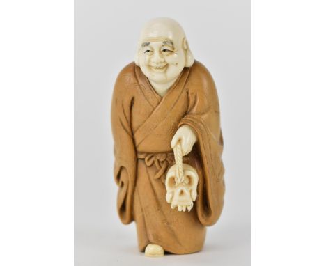 An early 20th century Japanese wood and ivory Okimono of a Chinese man wearing a Kimono carrying a skull on a piece of string