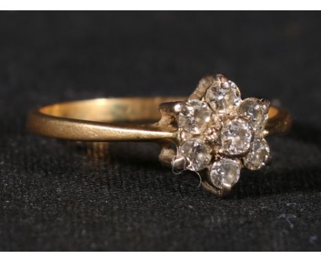 18ct gold seven stone diamond ring arranged in a flowerhead pattern, size P, 2.3g.