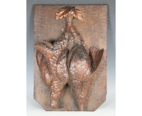 A late 19th century Black Forest carved walnut panel, modelled in high relief with a brace of hanging partridges, 44.5cm x 30