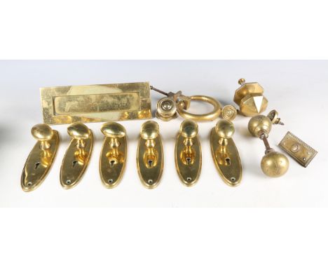 A collection of Victorian and later brass door furniture, including a ring shaped knocker, diameter 11cm, six oval door handl