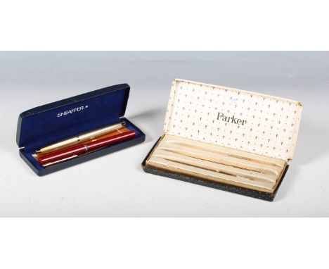 A Sheaffer USA gold plated fountain pen with engine turned decoration, with guarantee leaflet and case, two Parker gilt metal