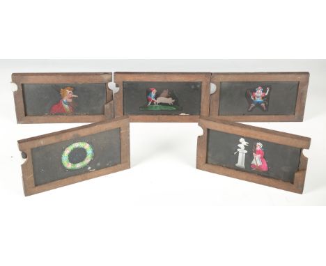 A group of eight 19th century mahogany framed glass magic lantern slides, painted mostly with amusing sliding scenes, togethe