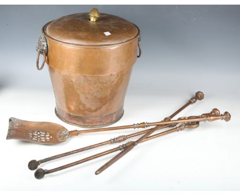 A set of three Victorian copper fire tools with pierced shovel and octagonal pommels, length 74cm, together with a copper lid