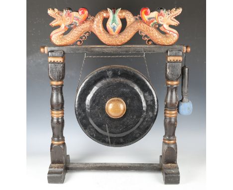 A 20th century Eastern carved and painted wooden dinner gong, height 70cm, width 53cm.Buyer’s Premium 29.4% (including VAT @ 