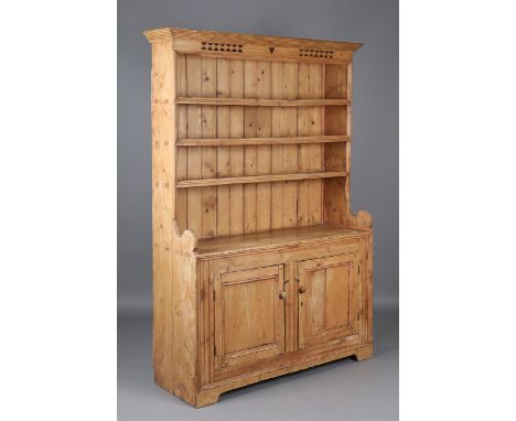 A 19th century Irish pine dresser, the integral shelf back above two panelled doors, height 201cm, width 142cm, depth 47cm.Bu