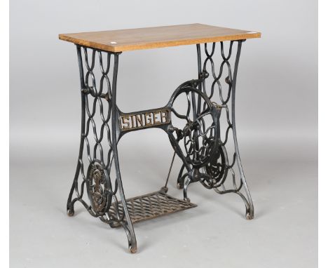 A Singer sewing machine treadle base, converted to a table and fitted with an oak top, height 74cm, width 66cm, depth 37.5cm.