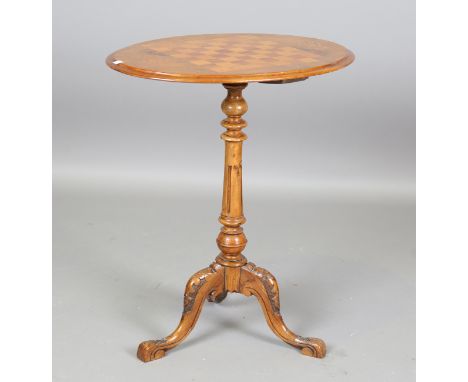 A late Victorian walnut oval games occasional table, the top inlaid with a chessboard, on a carved tripod base, height 70cm, 