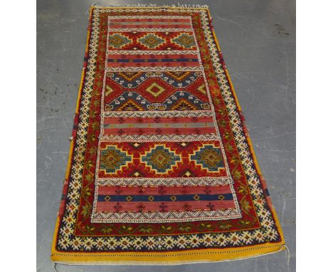 An unusual Moroccan rug, late 20th century, the polychrome field with sections of flatweave, 226cm x 107cm.Buyer’s Premium 29