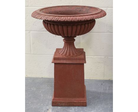 An early 20th century patinated cast iron garden urn of reeded campana form, raised on a square section pedestal, height 73cm