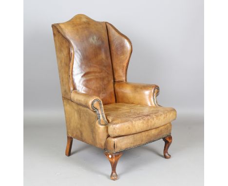 A mid-20th century George III style green leather wingback armchair, on cabriole legs, height 118cm, width 77cm, depth 84cm.B