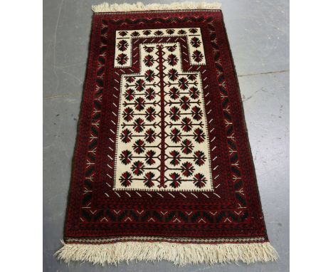 A Beluche prayer rug, Afghan/Persian borders, late 20th century, the ivory mihrab with overall flowering vine, 153cm x 87cm, 