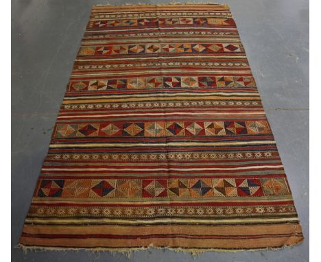 A Turkish kelim rug, early/mid-20th century, the polychrome banded field with embroidered geometric forms, 247cm x 144cm.Buye