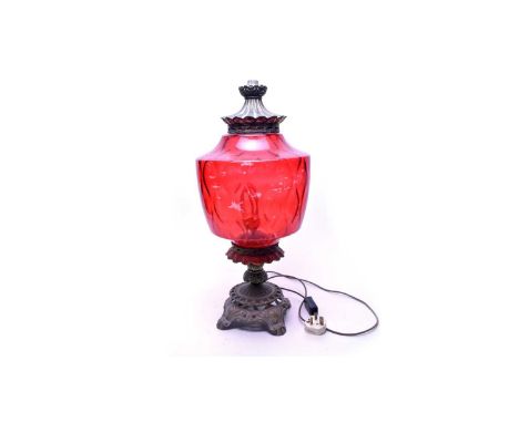 A Victorian style cast brass table lamp, with cranberry glass style shade, wired for electricity, 60cms high.