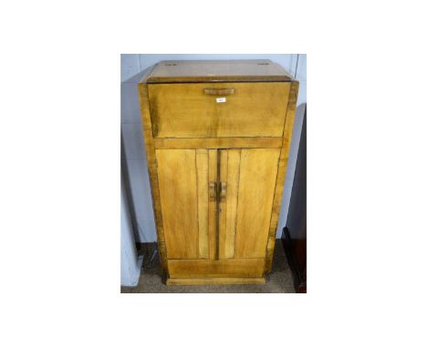 A 1930's walnut cocktail cabinet, the hinged top and fall-front opening together to reveal a fitted and mirrored interior, wi