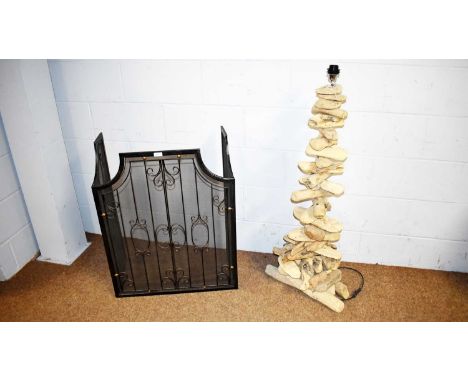 An unusual driftwood floor lamp, 121cms high; and a black metal fireguard, with scrollwork design, the central panel 63 x 80m