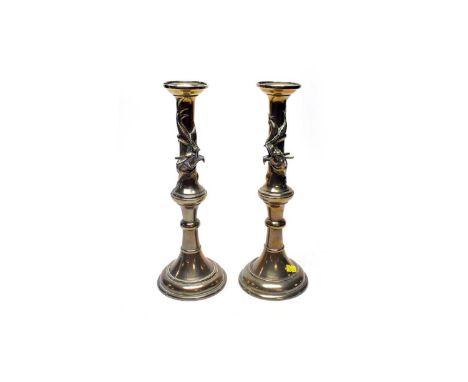 A pair of Japanese brass candlesticks, of pillar form with dragon motif decoration in high relief, each 33.5cms high. 