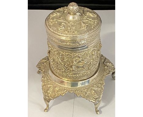 A late 19th century Burmese/Thai unmarked white metal tea caddy with stand with repousse decoration. Overall height 16cm. Wei