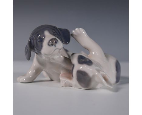 This Royal Copenhagen porcelain figurine, model 453, captures an endearing moment between two playful puppies in fine detail.