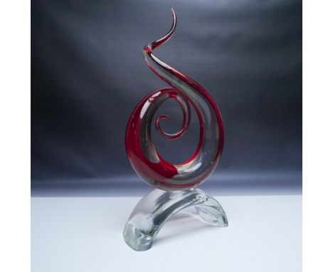 A captivating hand-blown art glass sculpture featuring an elegant swirling spiral form in deep ruby red with clear glass acce
