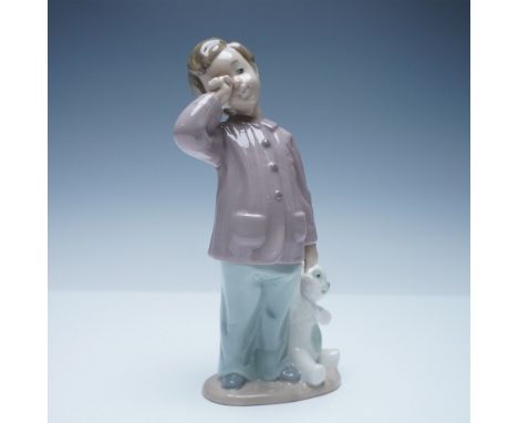 Endearing Nao by Lladro porcelain figurine featuring a young boy in pajamas rubbing his sleepy eyes while holding his cherish