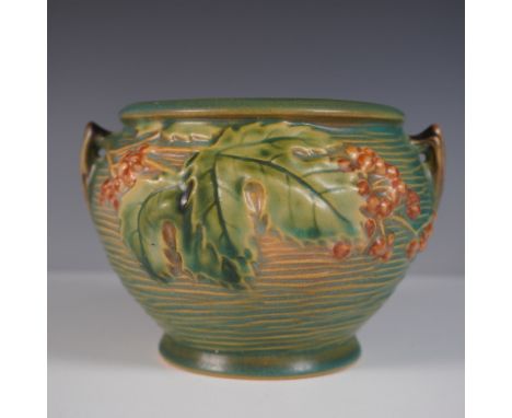 This Roseville Pottery Bushberry jardiniere is recognized for its intricate raised relief of clusters of berries, serrated le