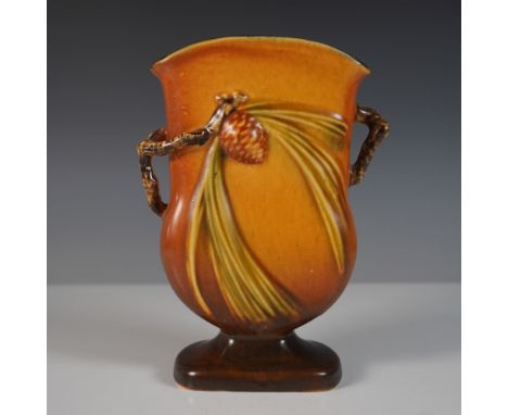 A Roseville Pottery vase from the iconic Pinecone line featuring a warm brown glaze with a relief design of pinecones and nee