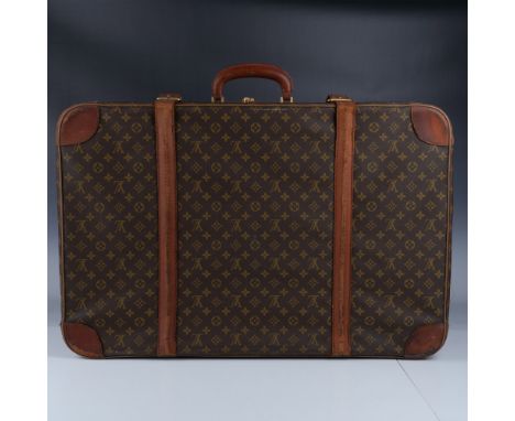 Vintage Louis Vuitton suitcase crafted from the iconic monogram canvas with natural leather trim and gold-tone hardware. This
