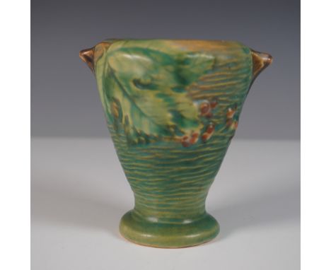 This Roseville Pottery Bushberry vase showcases the brand's signature Art Deco influence with a nature-inspired motif. The va