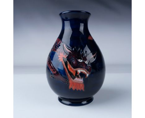 Moorcroft pottery vase featuring a striking dragon design. The vase showcases a bold palette of deep blue and vivid red, high