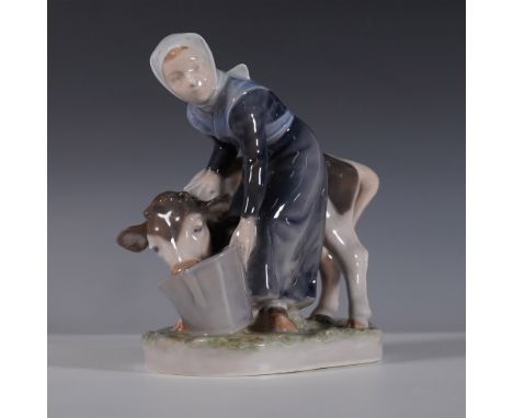 Royal Copenhagen porcelain figurine Girl Feeding Calf, style number 779. This charming hand-painted piece captures a rural sc