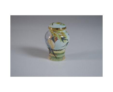 Moorcroft porcelain lidded jar featuring a finely hand-painted design of swallows and a finch perched on a branch, set agains