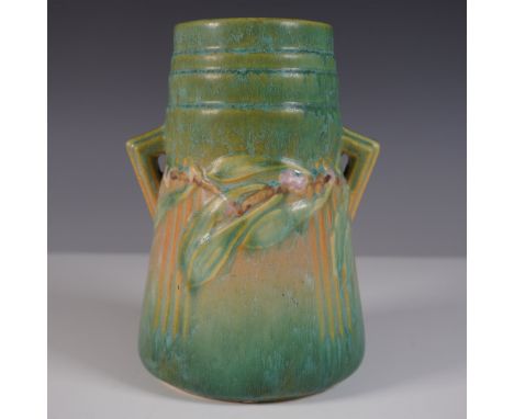 A distinctive Roseville Pottery Laurel vase in a soft green glaze, featuring an embossed laurel wreath motif encircling the b