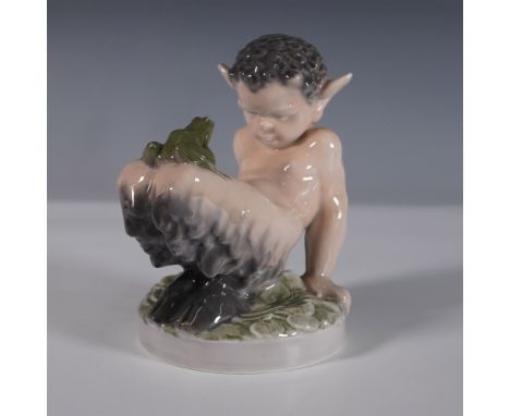 A charming porcelain figurine by Royal Copenhagen, depicting a young faun playfully interacting with a frog. Designed in a na