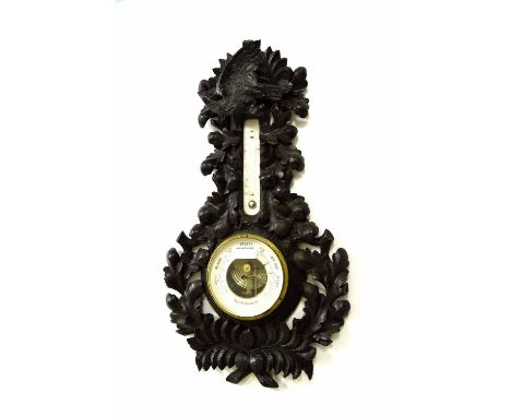 Aneroid barometer/thermometer, within an oak leaf pierced carved case surmounted by a bird with outstretched wings, 25" high